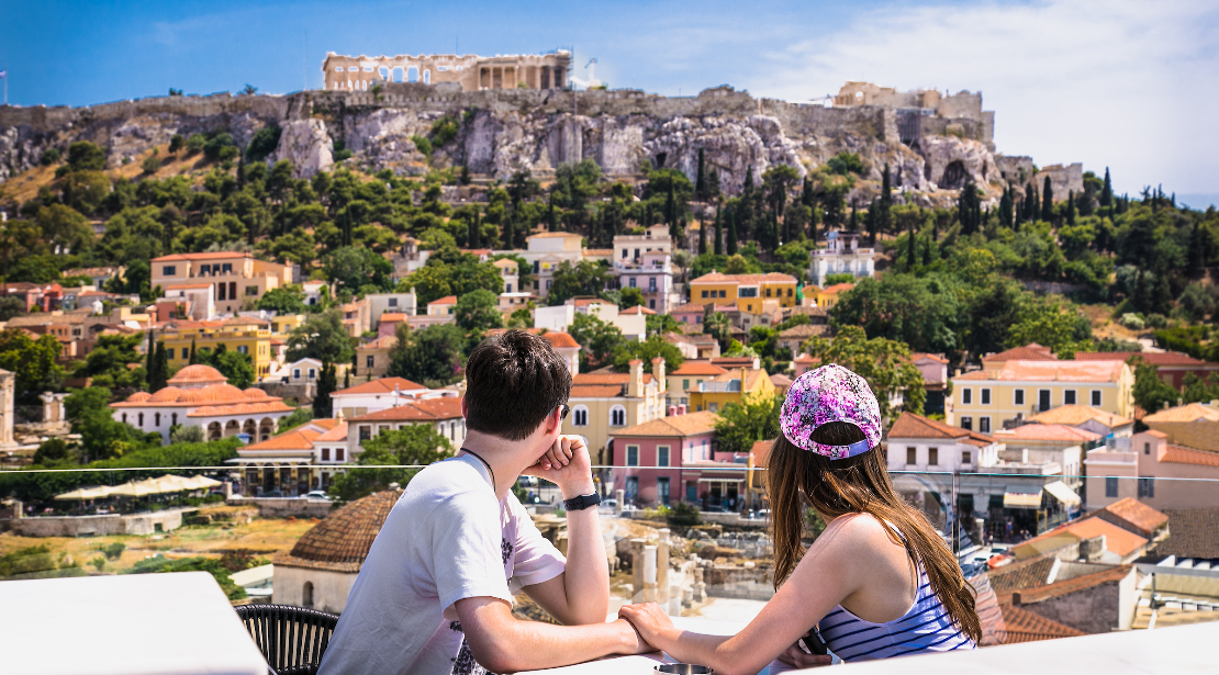 Two students sitting at a table taking in the vista of Athens