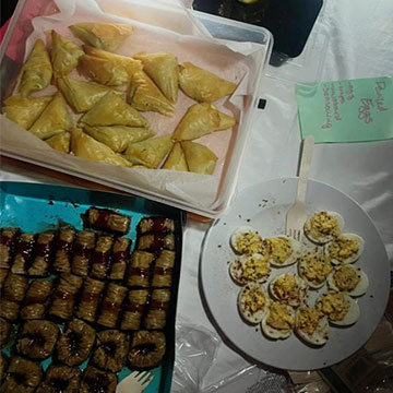 Three plates of food on the table - one being deviled eggs.