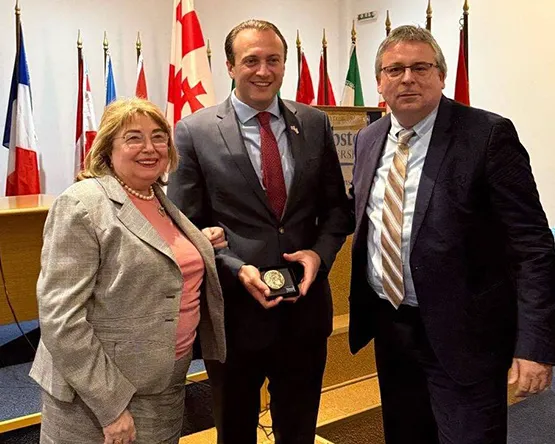 Vice Rector for Academic Affairs, Georgian Ambassador and Rector Botopoulos posing for a photo  while ambassador holding a plaque featuring an engraving of Alexander the Great 