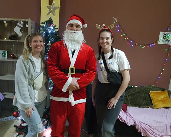 two students posing for a photo with the santa