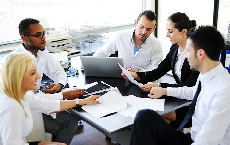 business colleagues discuss around an office desk