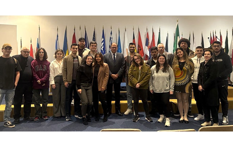 Moreno stands with Webster University Athens international relations students after his lecture.