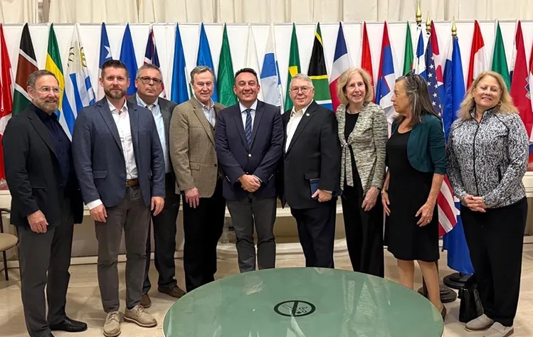 Webster President and leadership posing for a photo inside the Webster Athens Cultural Center