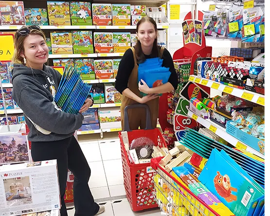 Students hold gift shopping bags inside a toy store