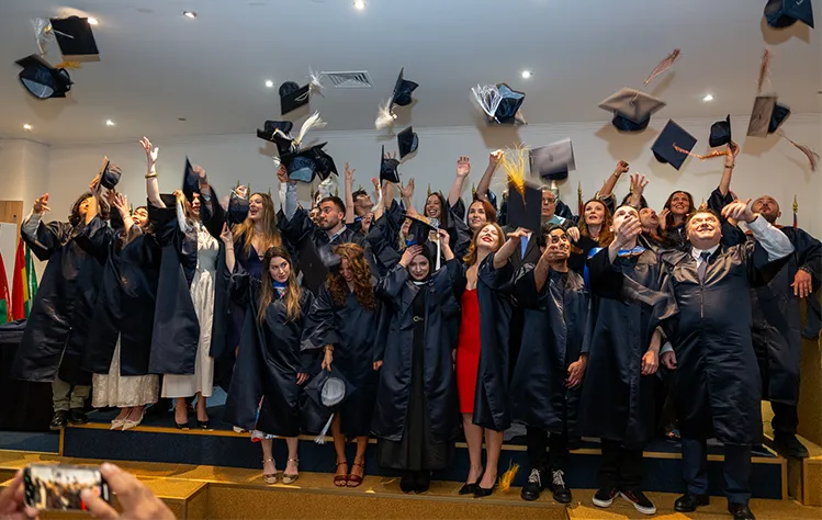 Graduates of the Webster Athens Class of 2026 toss their caps into the air following commencement ceremonies.